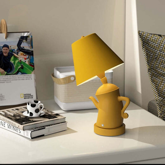 Alice Dream Kettle Lamp on bedside table, yellow kettle-shaped lamp providing ambient lighting.