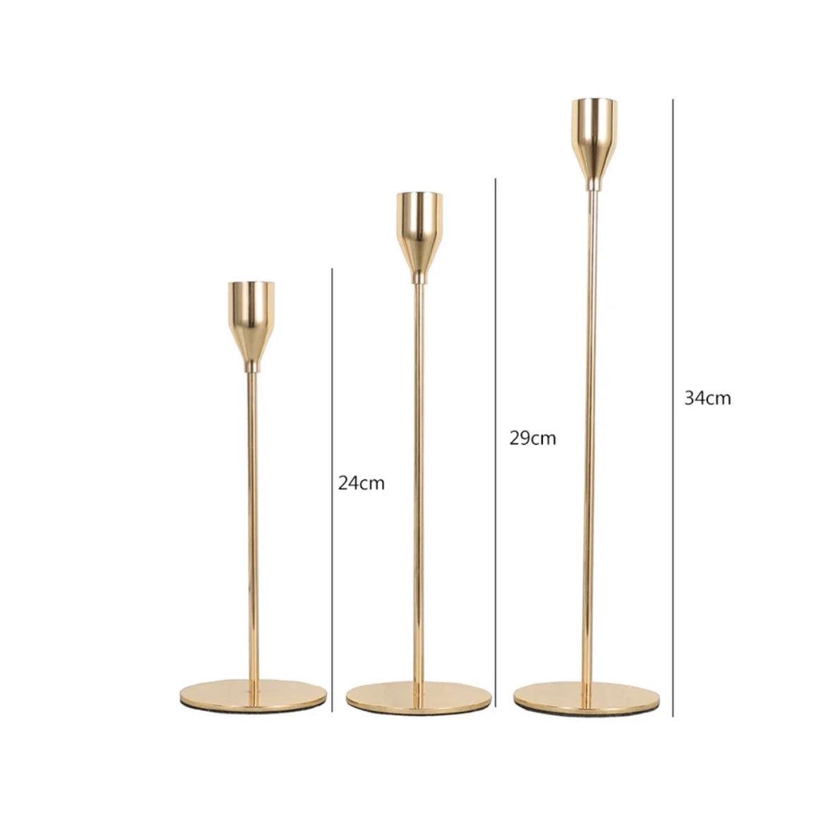 Elegant gold candlestick holders in three varying heights, perfect for adding charm to home decor.