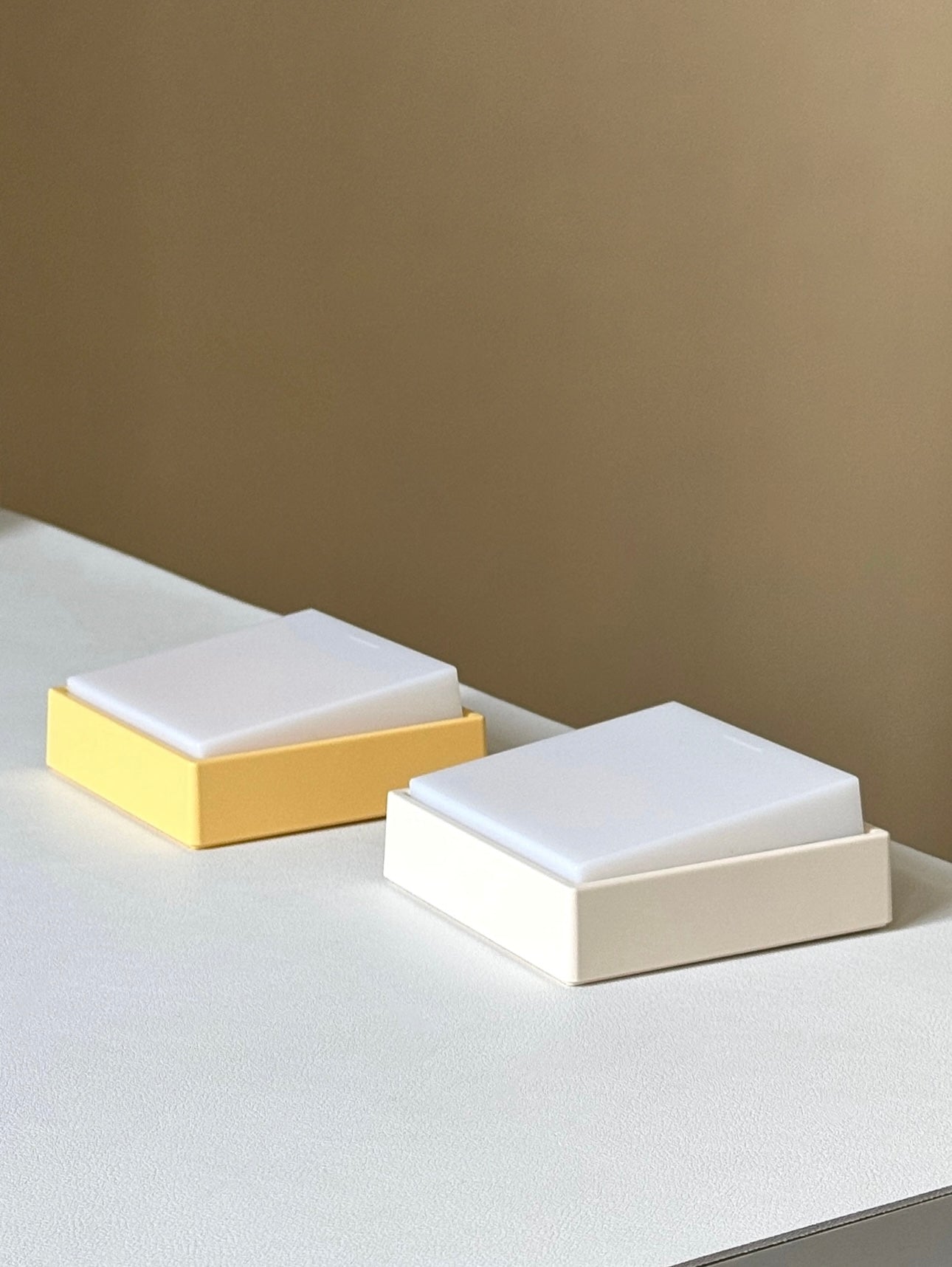Switch-shaped nightlight in yellow and white on a table, designed for easy nighttime lighting.