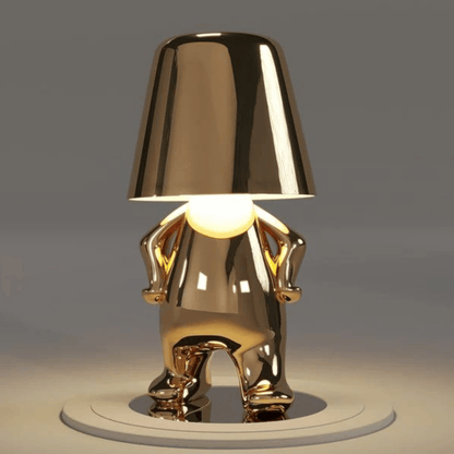 Thinker Brothers Table Lamp with a unique gold design, featuring a playful figure and elegant minimalist style.