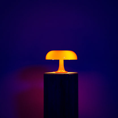 Lumiosa mushroom table lamp with warm orange glow on a pedestal, showcasing iconic Italian design and touch controls.
