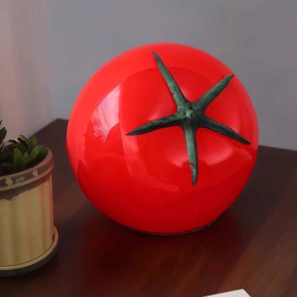 Tomato night light on a bedside table, featuring a quirky tomato shape with a green stem, perfect for cozy decor.