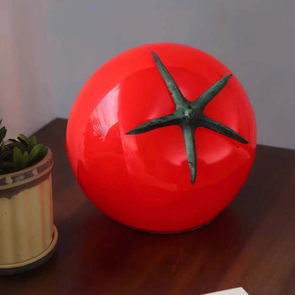 Tomato night light on a bedside table, featuring a quirky tomato shape with a green stem, perfect for cozy decor.