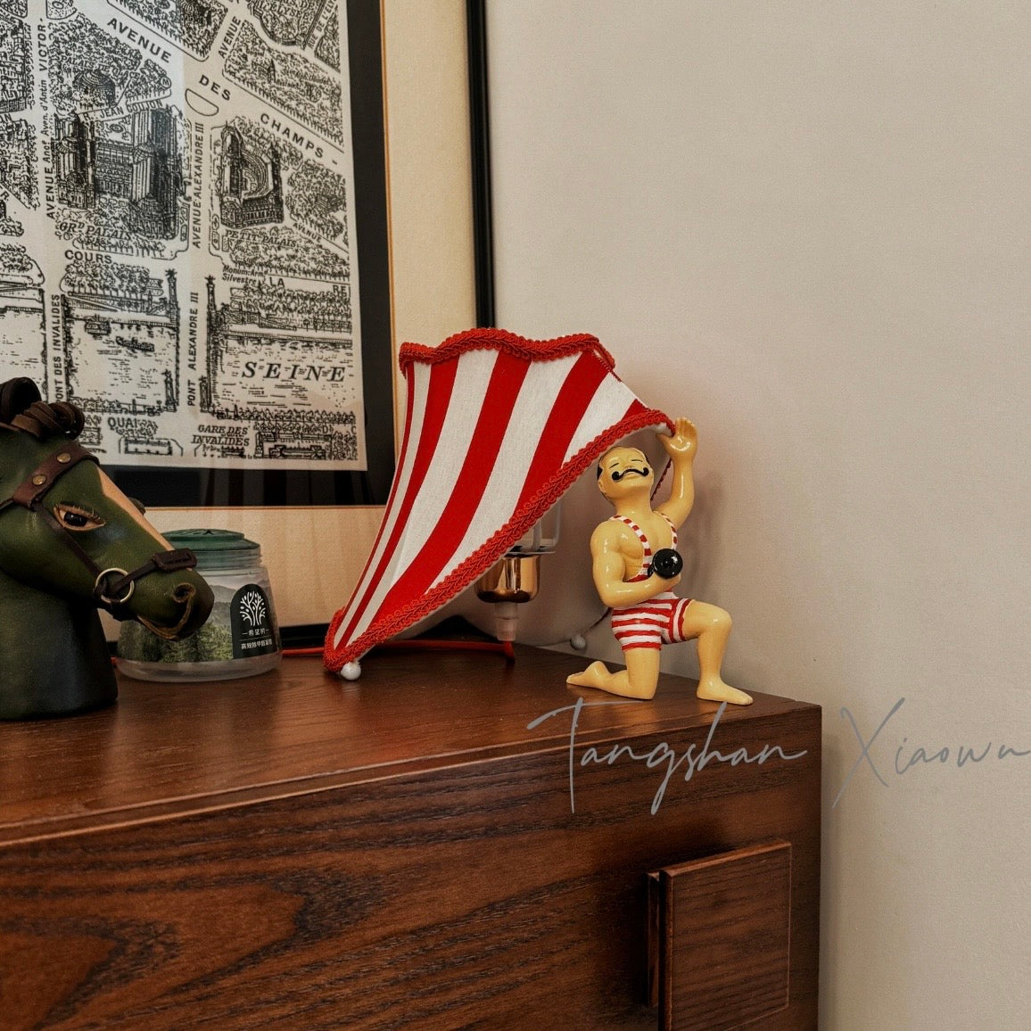 Circus Strongman Table Lamp on a wooden dresser, showcasing vintage charm and playful design.