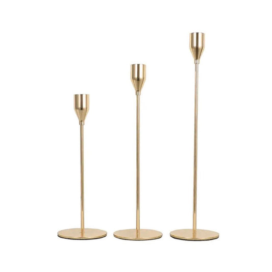 Elegant gold candlestick holders in three varying heights, perfect for enhancing home decor and creating a warm atmosphere.