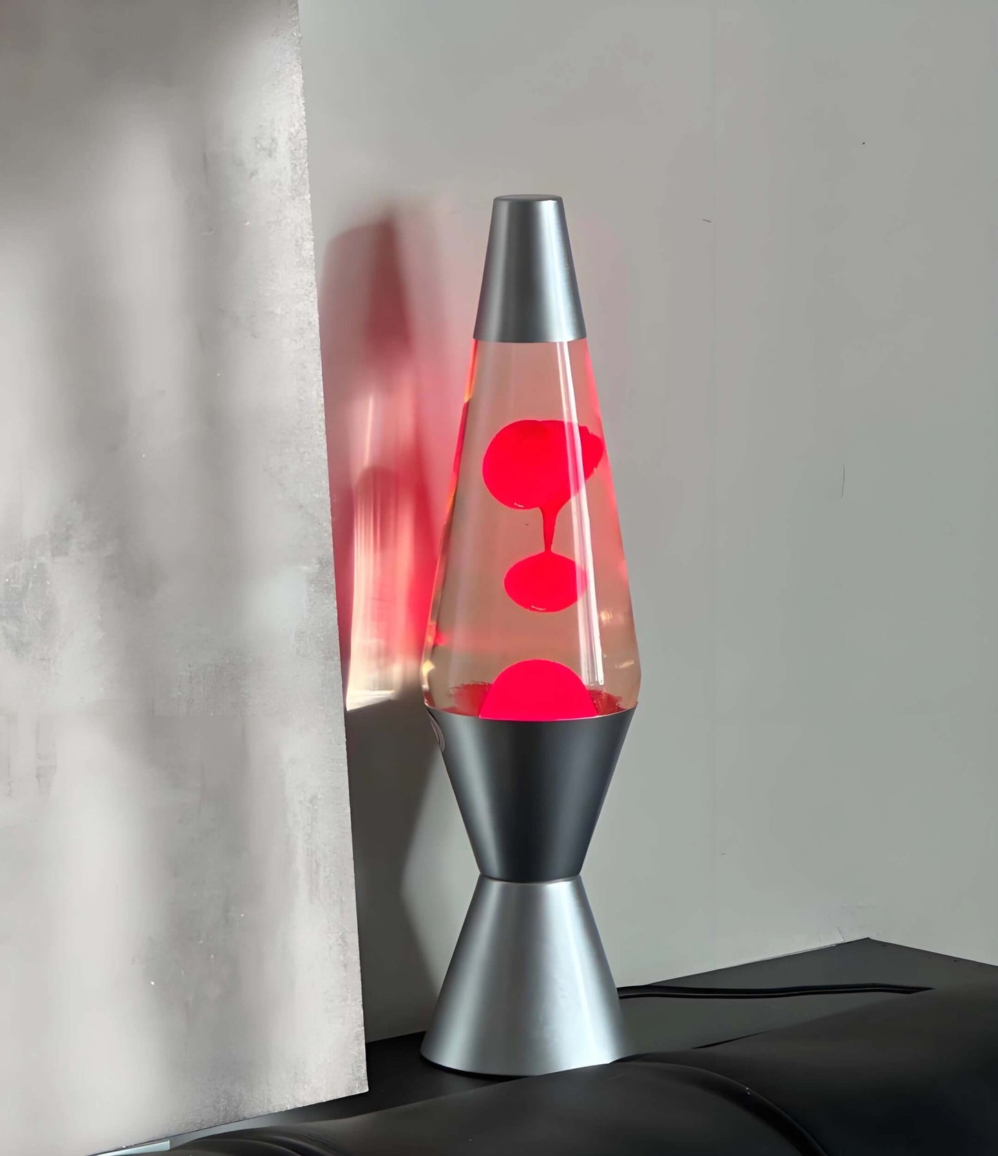 Dynamic wax lamp in silver with red blobs floating, creating a soothing mood light for relaxation.