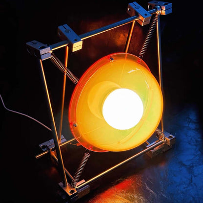 Sculptural orange acrylic table lamp with stainless steel frame and exposed springs
