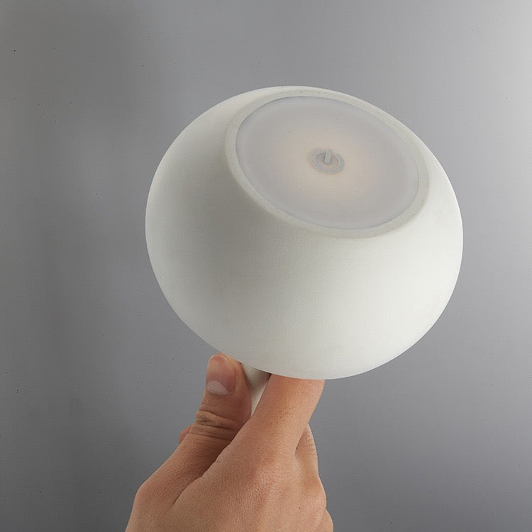 Hand holding the Tokyo table lamp featuring a sleek, minimalistic design with touch sensor and brightness adjustment.