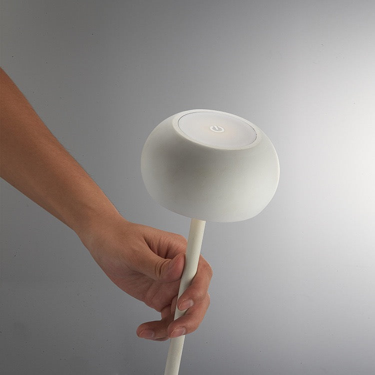 Tokyo table lamp held by a hand, showcasing Scandinavian design, touch sensor, and sleek minimalist style.