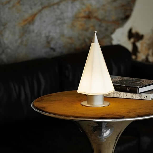 Handcrafted cedar lamp with soft glow on a table, creating a cozy ambiance in a stylish living room.