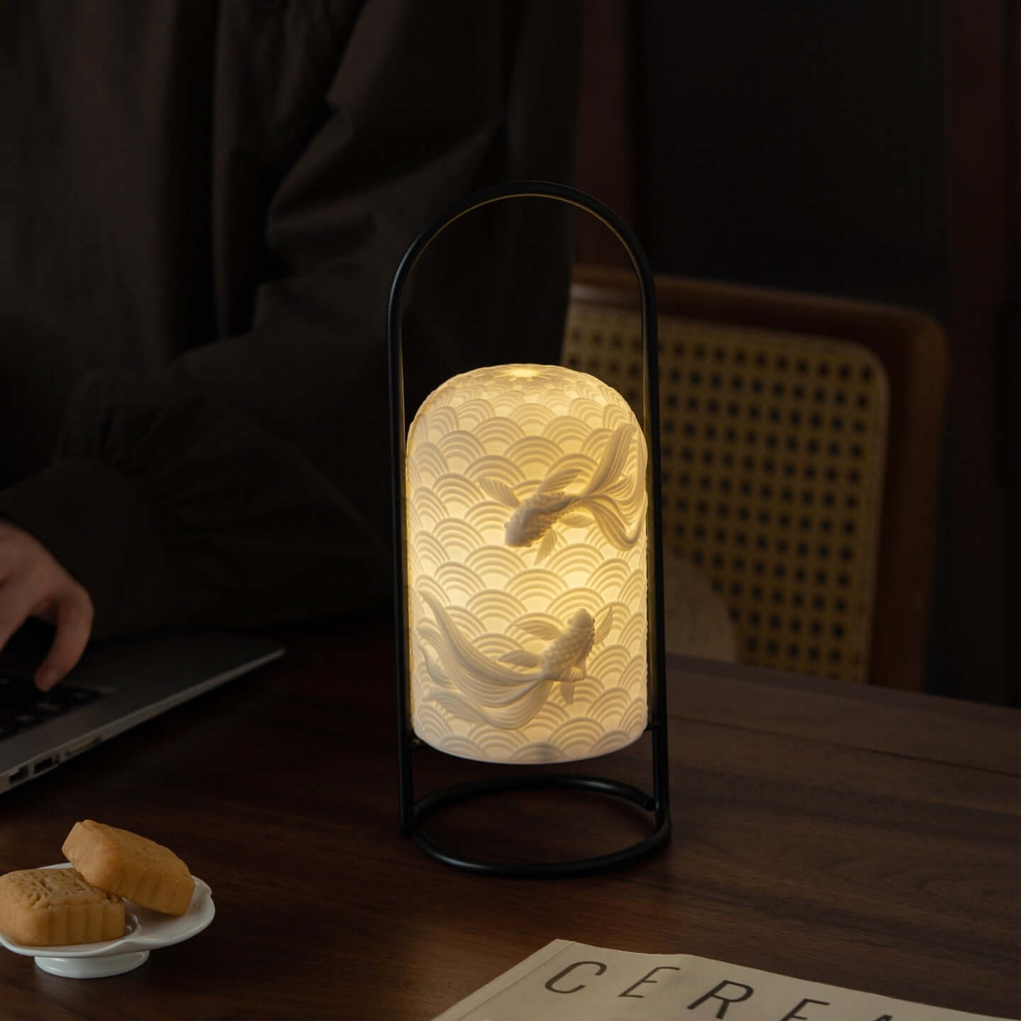 Ceramic Goldfish Lamp on a table, showcasing its intricate design and soft illumination for a cozy ambiance.