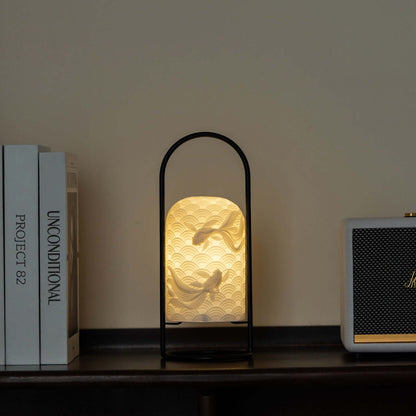 Ceramic goldfish lamp illuminating a shelf, showcasing its intricate design and modern style.