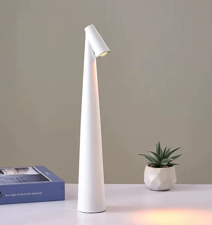 Sleek white touch-control LED desk lamp beside a plant and books, showcasing modern minimalist design.