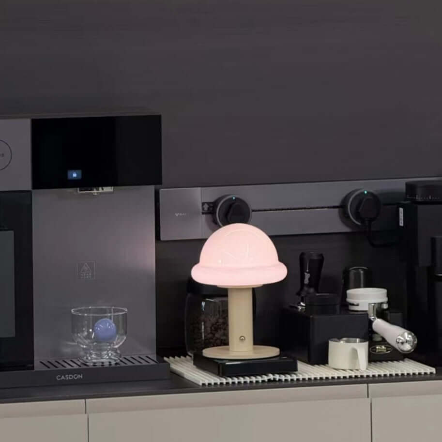 Candy Table Lamp glowing softly on a kitchen counter, surrounded by coffee equipment and a glass.