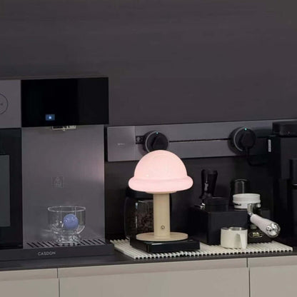 Candy Table Lamp glowing softly on a kitchen counter, surrounded by coffee equipment and a glass.