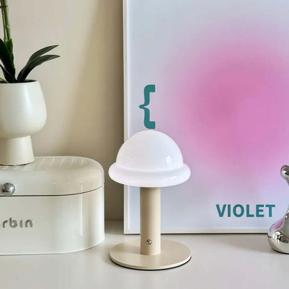 Candy table lamp with white dome shade, beige base, and colorful backdrop, perfect for mood lighting.