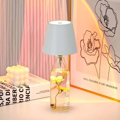 Creative wine bottle lamp with a gray shade, featuring decorative flowers and a soft glow on a stylish table.