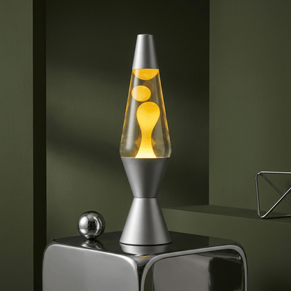 Lava lamp with a sliver base and cap, clear liquid, and yellow wax.